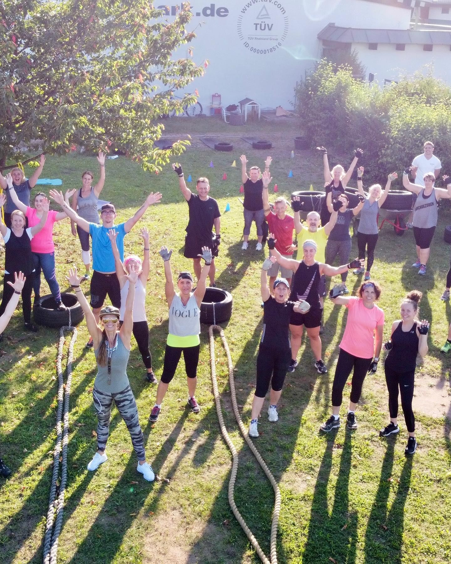 Kursgruppe beim Bootcamp im Garten des BEYERS AKTIV-PARK, alle Arme in der Luft
