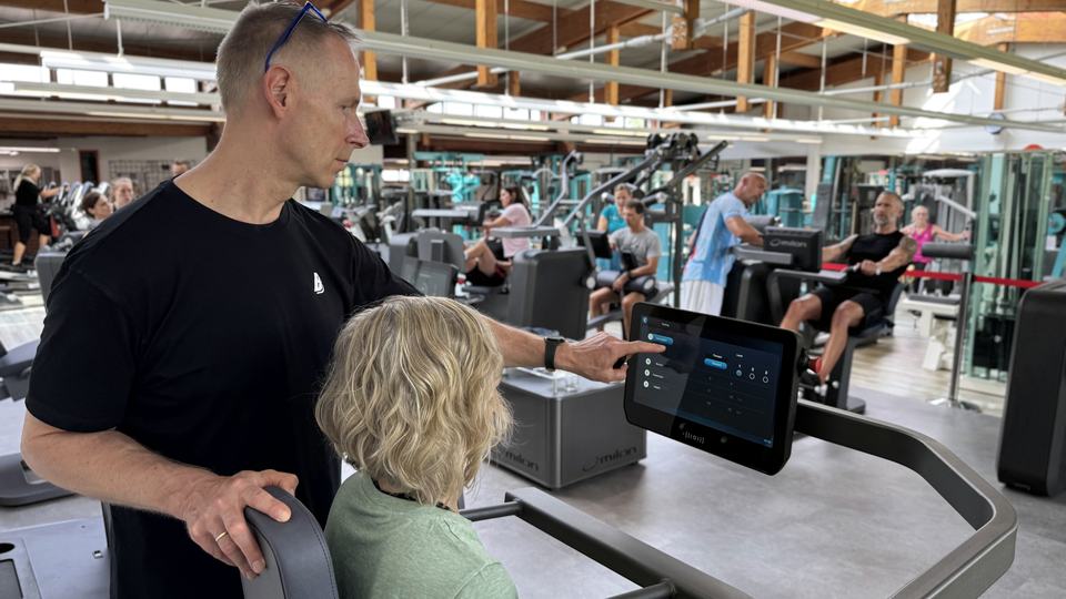 Trainer und Mitglied besprechen die Werte am Bildschirm des milon-Zirkels