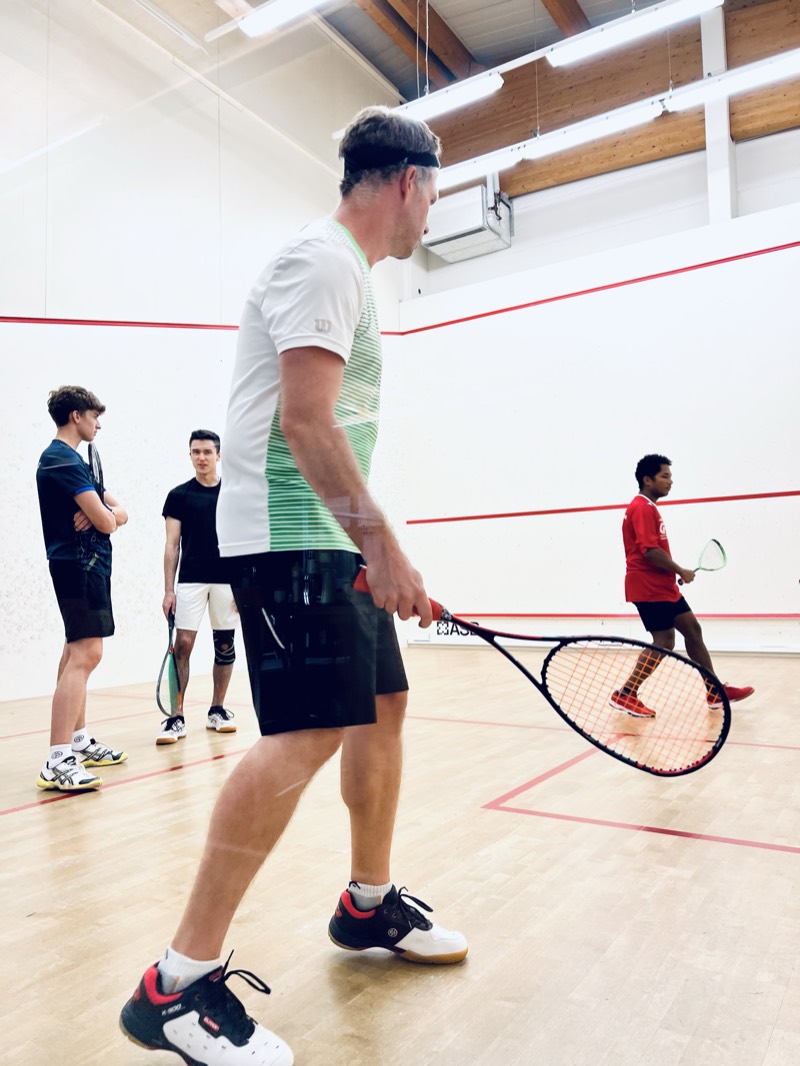 Zwei Spieler im Ballwechsel auf dem Squash-Court